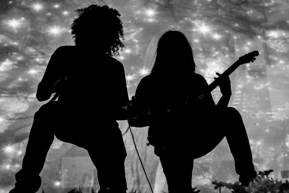 A thrash guitarist drives a packed club crowd