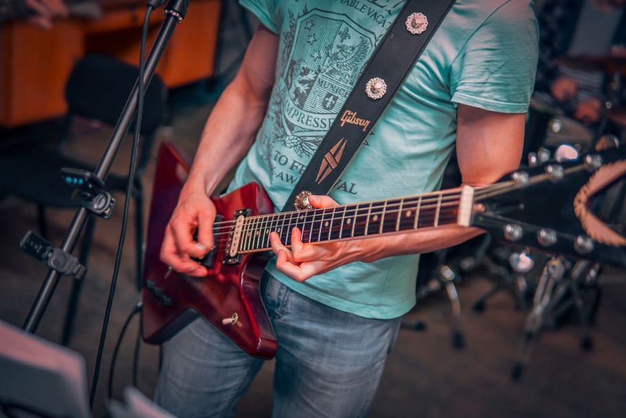 An acoustic guitar rests near rehearsal amplifiers