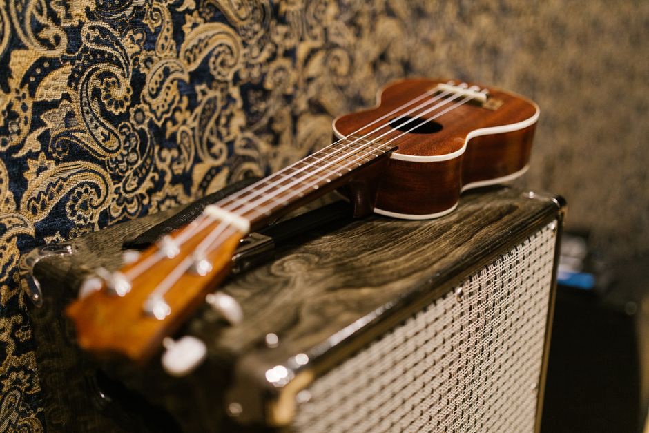 Guitarist rehearsing a fast lead passage beside amplifiers