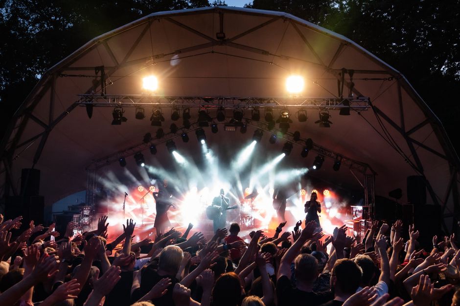A guitarist moves across a wide festival stage