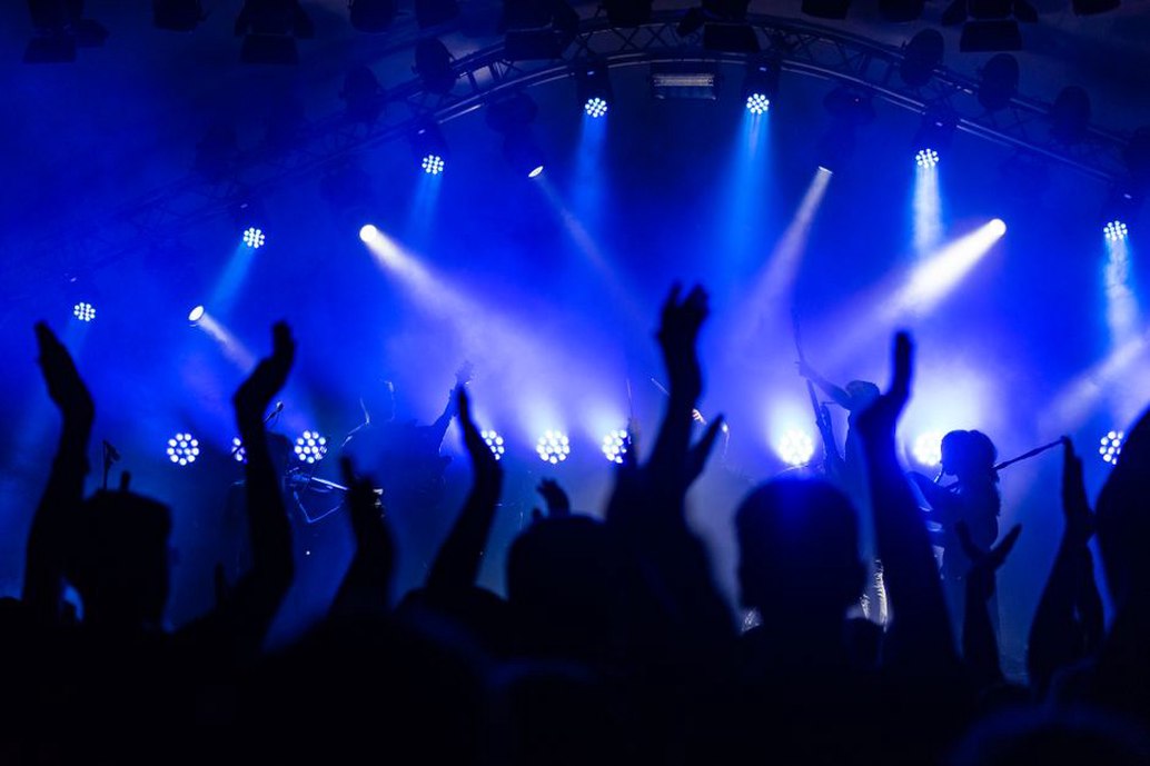 Crowded club audience facing a thrash metal stage