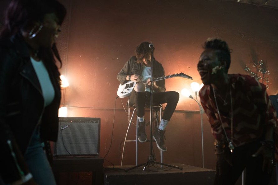 Guitarists performing beneath crowded club lights