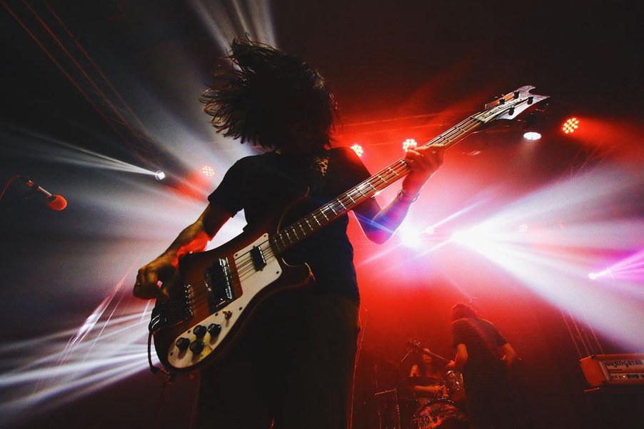 festival audience headbanging in a dust cloud at an open-air thrash metal performance