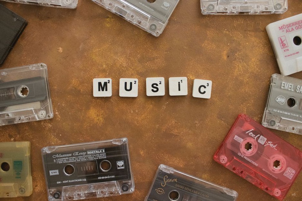 A printed gig flyer rests beside a cassette