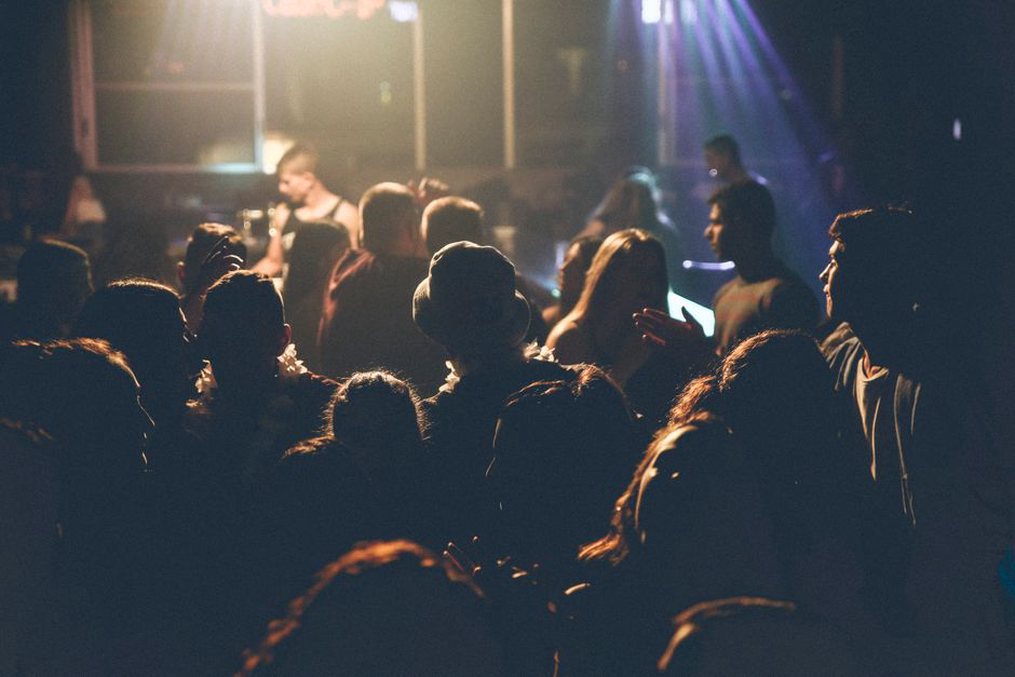 A close crowd facing a small thrash stage