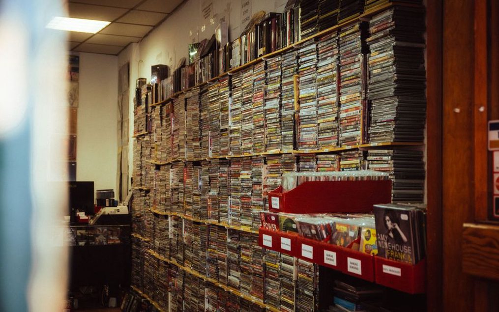 CDs and shirts arranged beside a small venue stage