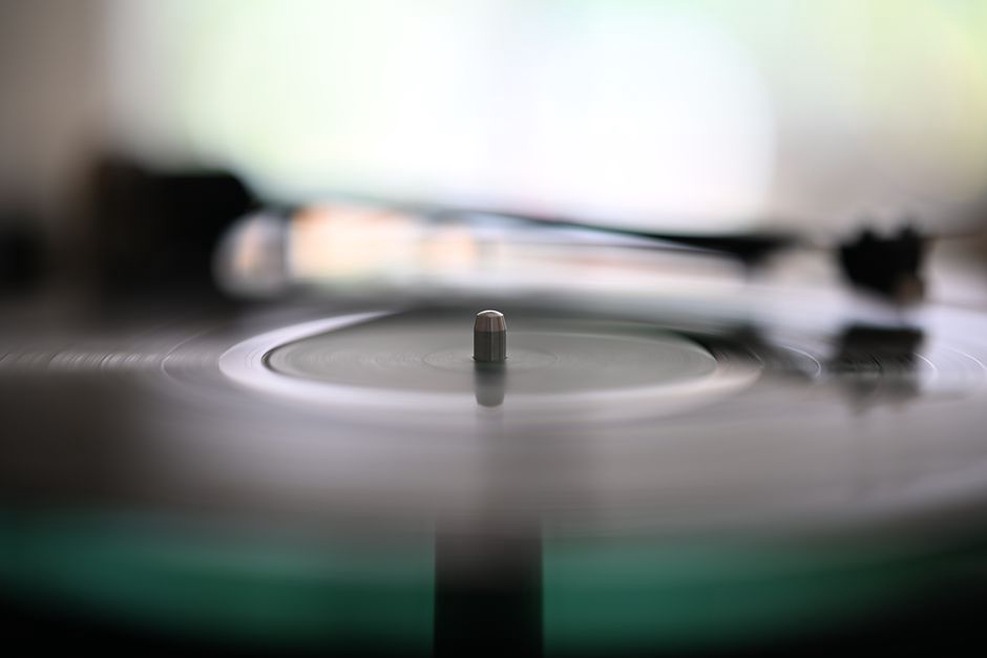 a black vinyl LP from a Finnish thrash metal band playing on a turntable with a slipmat visible