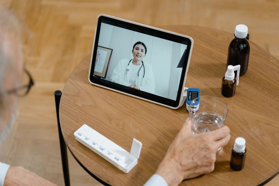 Medication list ready beside a laptop for a video visit